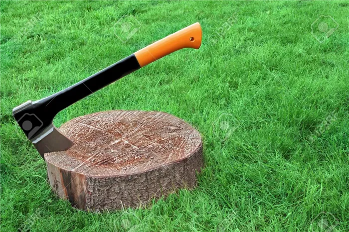 Modern Axe Or Wood Splitter Set In Chopping Block Close-up Grass On The Background With Copy Space